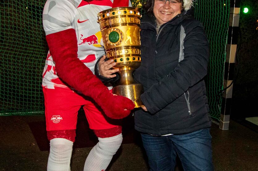 RB Leipzig-Maskottchen „Bulli“ mit DFB-Pokal und Regionalstellenleiterin Manuela T. 